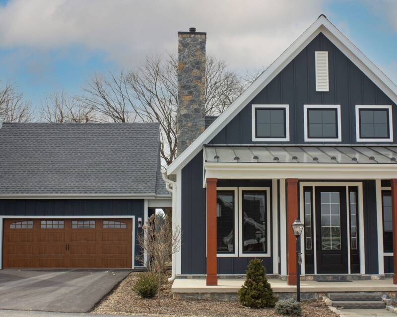 Stone Chimney With Black Board-and-batten Siding