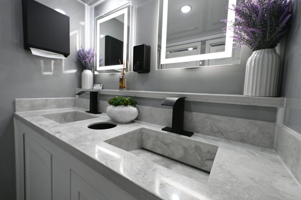 A bathroom featuring two sinks with modern faucets and large mirrors above each sink.